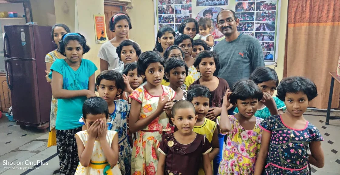 Children gathered with a Surya Helping Hands volunteer at a community celebration